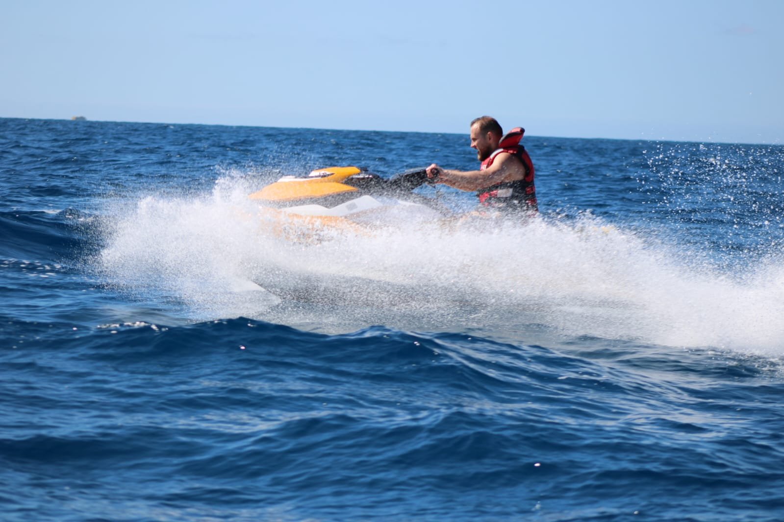 Couple on a black and white Sea-Doo jet ski with the dramatic mountains of Lanzarote in the background